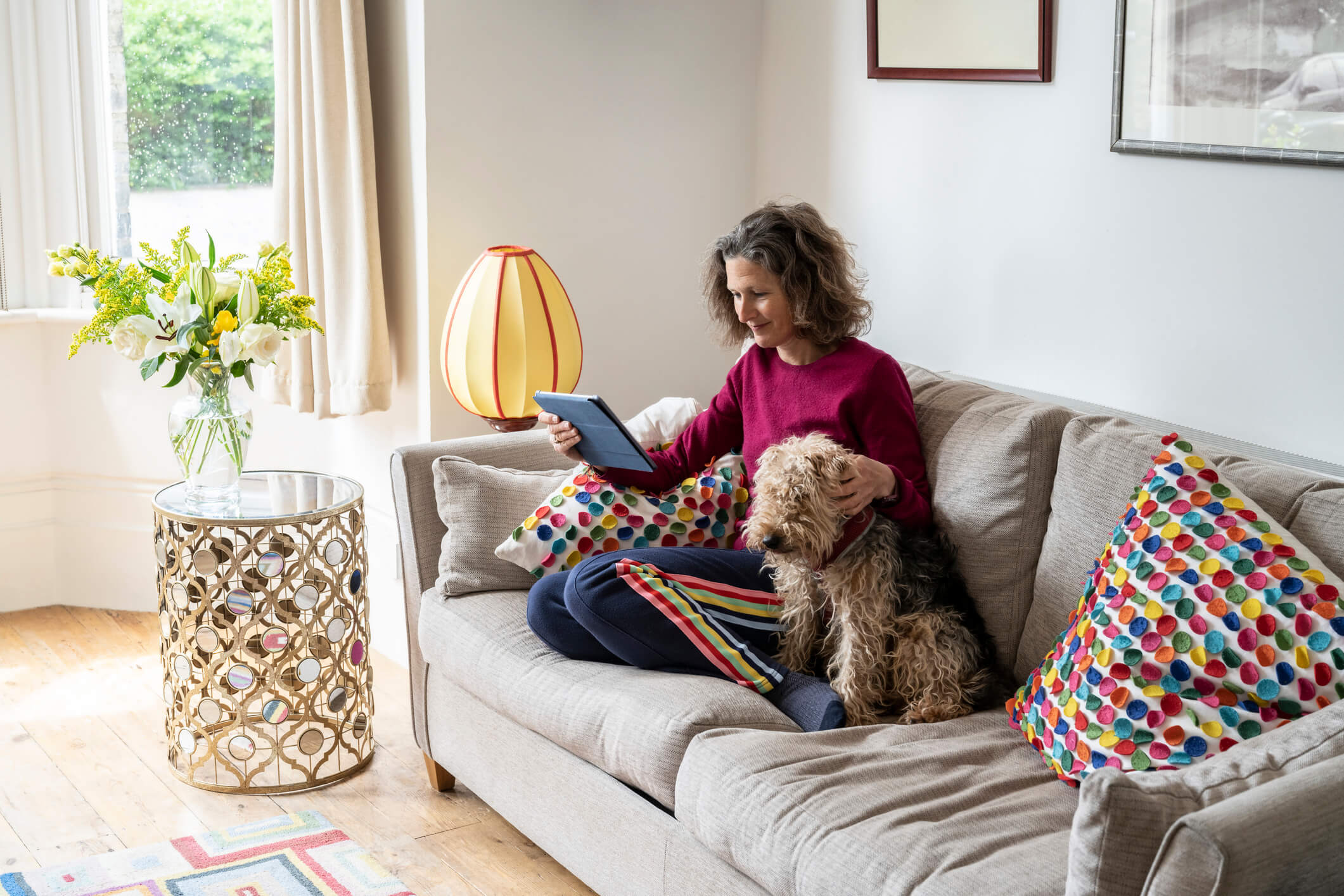 Woman and dog sitting on sofa