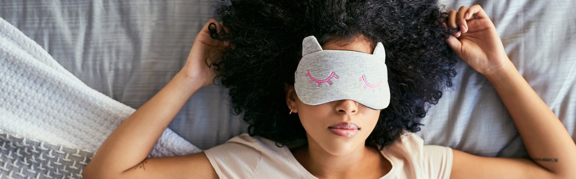 Woman wearing eye mask in bed